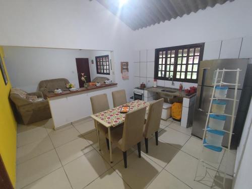 een keuken met een tafel met stoelen en een keuken met bij Chácara da Vó na Natureza in Mogi das Cruzes