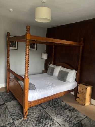 a bedroom with a canopy bed with white sheets and pillows at Three Tuns Ashwell in Ashwell