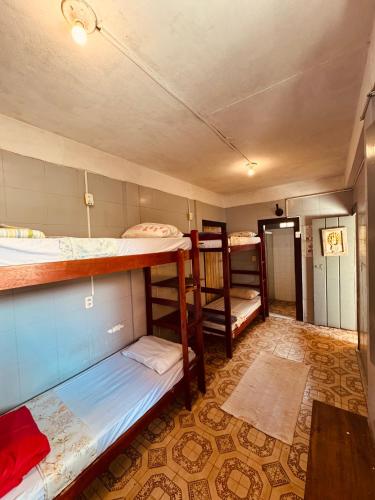a room with three bunk beds and a table at Maracujá Hostel in Paraty