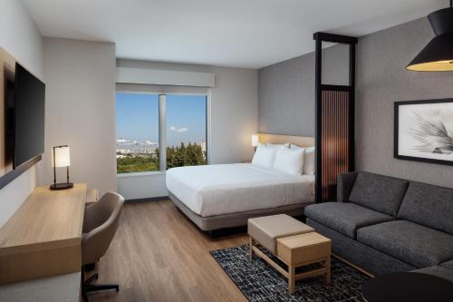 a hotel room with a bed and a couch at Hyatt Place Cape Canaveral in Cape Canaveral