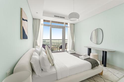 een witte slaapkamer met een wit bed en een raam bij VayK - Spacious 2BR Inside Hotel in Dubai