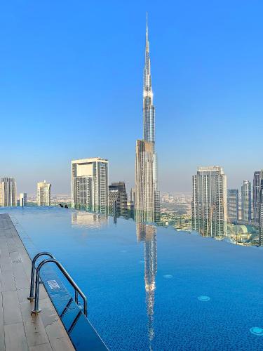 een zwembad met uitzicht op de stad bij VayK - Spacious 2BR Inside Hotel in Dubai