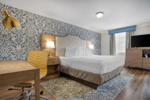 a hotel room with a bed and a desk and a computer at Best Western Plus French Quarter Courtyard Hotel in New Orleans