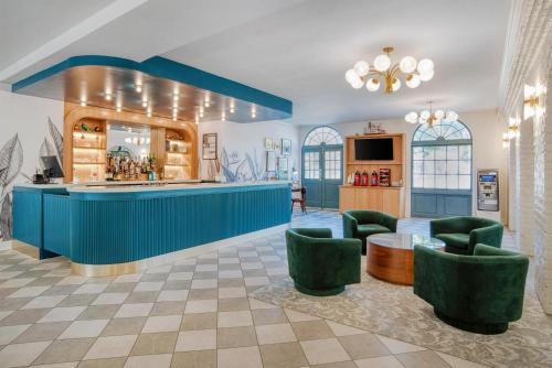 a lobby with a blue counter and green chairs at Best Western Plus French Quarter Courtyard Hotel in New Orleans