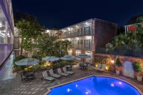 an outdoor swimming pool with patio furniture and umbrellas at Best Western Plus French Quarter Courtyard Hotel in New Orleans