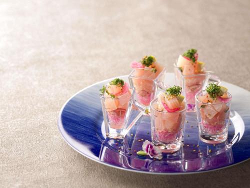 een dienblad met vier kopjes dessert op een bord bij Mercure Saga Karatsu Resort in Karatsu