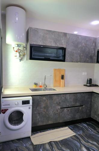 una cucina con lavatrice e lavandino di NOVA PREMIUM ROOMs a Dakar