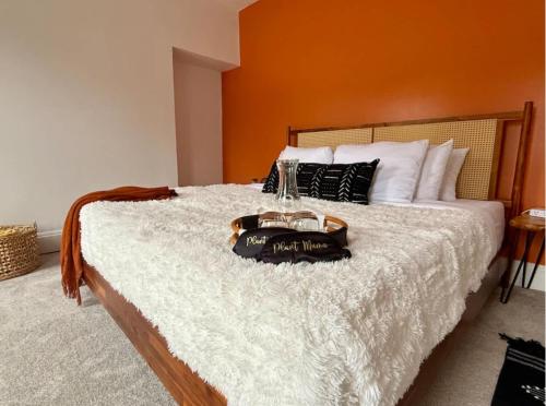 een slaapkamer met een bed met een oranje muur bij Jungle House Columbus Short North Downtown Free Parking - Near Convention Center & Nationwide Arena - 4BR Luxury Home - Sleeps 12 - Over 5,800 Five Star Stays in Columbus