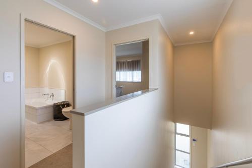un bagno bianco con lavandino e specchio di Stylish apartment Whanganui a Whanganui