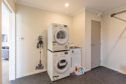 a laundry room with a washer and a washing machine at Stylish apartment Whanganui in Whanganui
