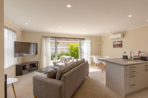 a kitchen and living room with a couch and a table at Stylish apartment Whanganui in Whanganui
