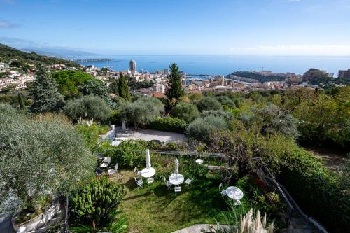 een tuin met uitzicht op de stad en de oceaan bij Le Mas d'Angeline-Vue mer panoramique, jardin partagé, parking, voiture indispensable, route étroite et pentue, à 10 min de Monaco in Beausoleil