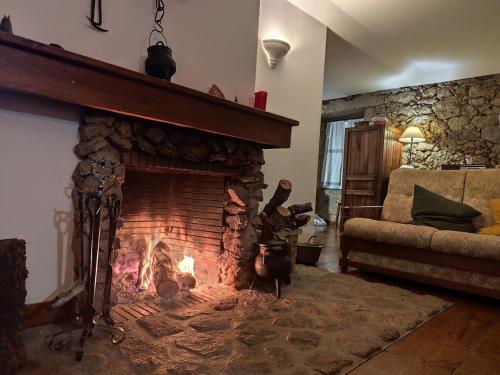 a fireplace in a living room with a fire at casa na aldeia - entre Fundão e Covilhã in Pêro Viseu