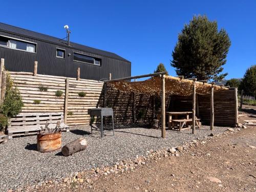a garden with a fence and a table and a chair at Cabaña - 5to Rincon Meliquina Home in Villa Meliquina