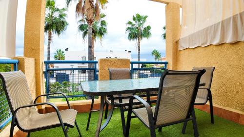 ein Tisch und Stühle auf einem Balkon mit Palmen in der Unterkunft Apartalux Vera Palace in Vera