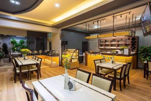 a dining room with tables and chairs and a restaurant at The Ring Residence in Sathani Hat Yai