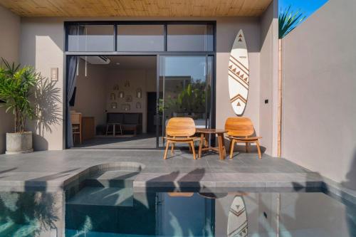 two chairs and a table next to a swimming pool at The Wood Terrace in Ban Chin Tham Mai