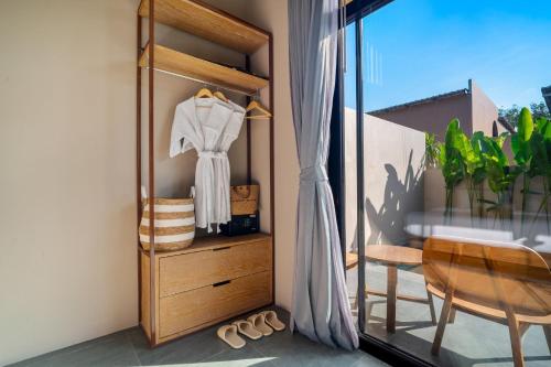 a closet with a dresser and a table and a window at The Wood Terrace in Ban Chin Tham Mai