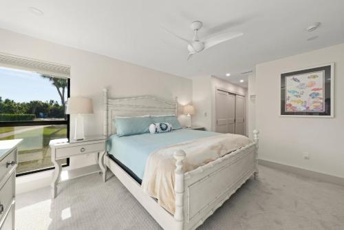 een witte slaapkamer met een groot bed en een raam bij Ground Floor Luxury - Your choice of 2 Bikes or Kayak Rental - Steps to Beach! in Sanibel