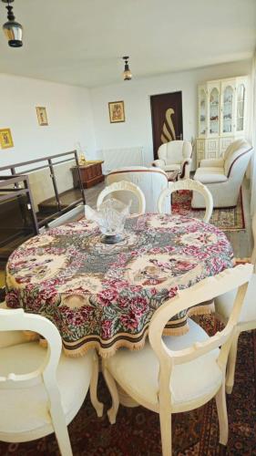 ein Esszimmer mit einem Tisch mit geblümter Tischdecke in der Unterkunft Casa Sulfina in Radoşi