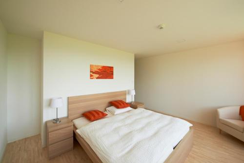 a white bedroom with a bed and a couch at Bio Garni Möschberg in Grosshochstetten