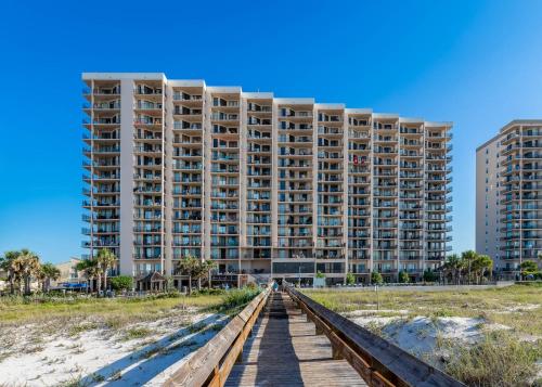 a building on the beach with a boardwalk in front of it at Phoenix East 002 in Orange Beach