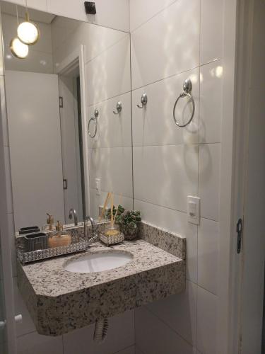 a bathroom with a sink and a mirror at Calmaria in Matinhos