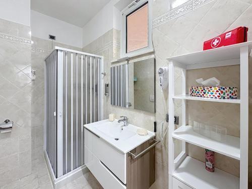 een witte badkamer met een wastafel en een spiegel bij Alloggio Turistico - I tre Moschettieri - Zona Universitaria e Tribunale Nuovo in Viterbo