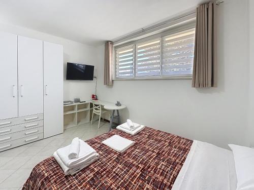 een witte slaapkamer met een bed en een bureau bij Alloggio Turistico - I tre Moschettieri - Zona Universitaria e Tribunale Nuovo in Viterbo