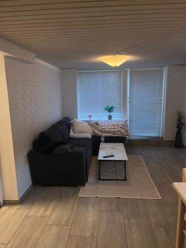a living room with a black couch and a table at Cozy Corner in Augustenborg