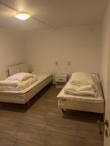 a room with two beds and a lamp in it at Cozy Corner ferielejlighed in Augustenborg