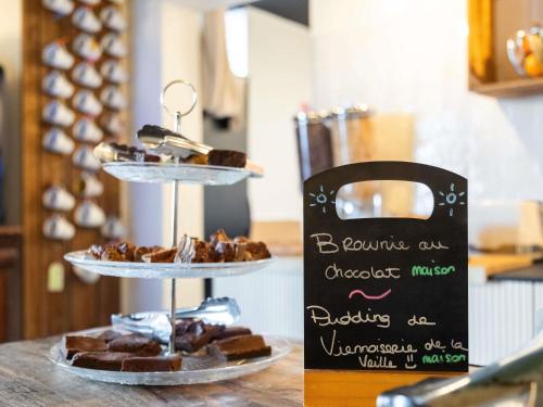 een drielaagse presentatie van gebak op een toonbank bij Greet Hotel Limoges Nord in Limoges