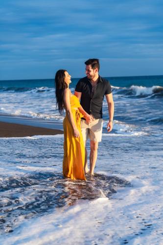 a man and a woman standing in the water on the beach at Villas La Mar in Monterrico