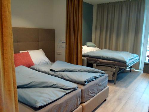 a room with two beds and a mirror at Lakeside Central Apartment Wörthersee - Free covered Parking, Train & Bus & Supermarket with Supercharger in Sekull