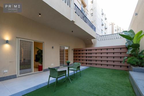 a courtyard with a table and chairs on a building at Prime Residence Zayed Heights in Sheikh Zayed