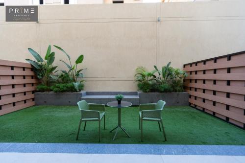 a patio with a table and two chairs and grass at Prime Residence Zayed Heights in Sheikh Zayed