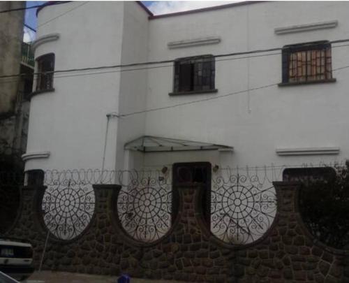 a white building with a fence in front of it at Hospedaje en habitación casa colonial centro histórico Puebla in Puebla