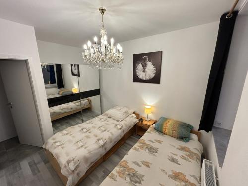 ein Wohnzimmer mit einem Bett und einem Kronleuchter in der Unterkunft Helmstedt Zentrum - Gemeinschaftshaus & Garten in Helmstedt