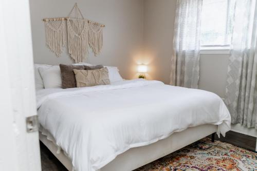 ein weißes Bett in einem Schlafzimmer mit einem Fenster in der Unterkunft Parkside & Broadview Memphis Comfort in City Ctr in Memphis