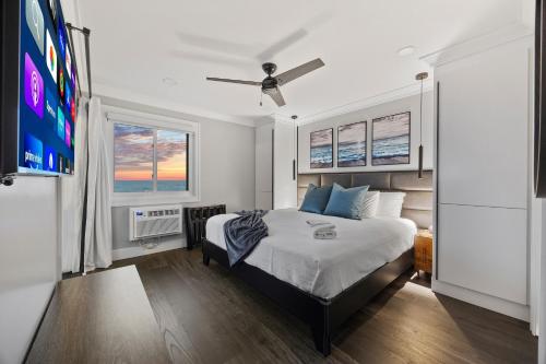 a bedroom with a bed and a flat screen tv at Modern Escape - Luxe Oceanfront 2BR with Epic Kitchen, Pool, Parking in Myrtle Beach