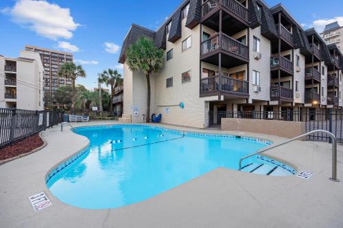 a swimming pool in front of a apartment building at Modern Escape - Luxe Oceanfront 2BR with Epic Kitchen, Pool, Parking in Myrtle Beach