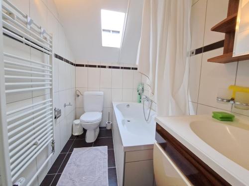 een badkamer met toilet, wastafel en bad bij Joli appartement de 3 pièces in Saint-Imier