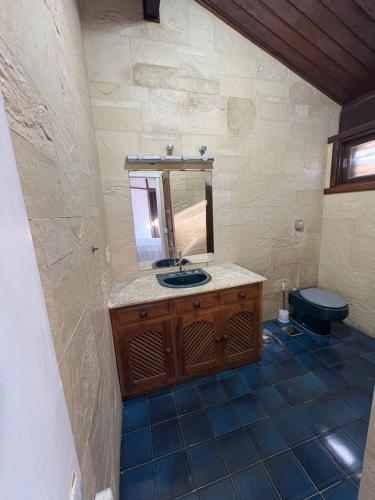 a bathroom with a sink and a mirror at Pé na areia 5 in Torres