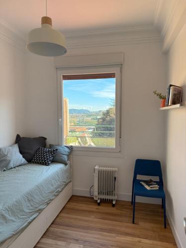 a bedroom with a bed and a large window at Gran Bilbao LaGa Apartamentos in Basauri
