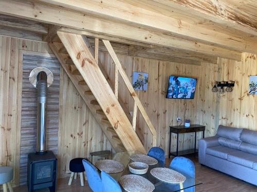 een woonkamer met een tafel en blauwe stoelen bij Cabañas alto de coñaripe in Coñaripe