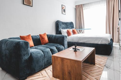 a living room with a blue couch and a bed at Kilimani Chic Studio in Nairobi