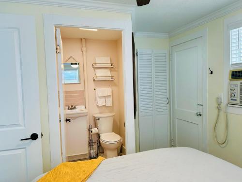 a white bathroom with a toilet and a sink at Safety Harbor Motel in Safety Harbor