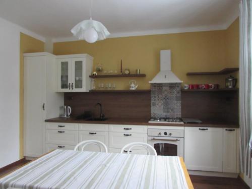 a kitchen with white cabinets and a table with chairs at Dům u rybníka in Nýdek