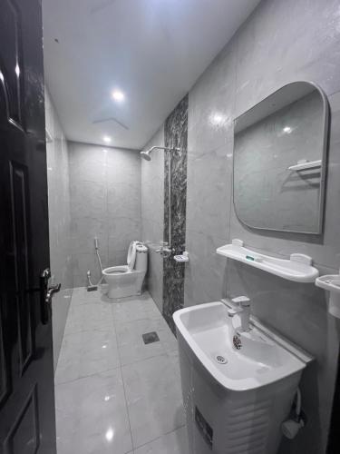 a bathroom with a sink and a toilet and a mirror at Gulberg Residency Hotel in Lahore