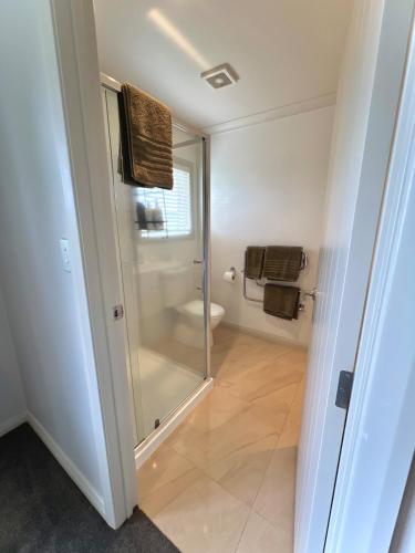 a bathroom with a shower and a toilet in it at Parkside in Bethlehem in Tauranga